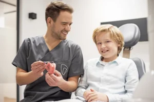 Kieferorthopädie in Krefeld - Dr. Kaesmacher zeigt einem Jungen ein KFO Ergebnis